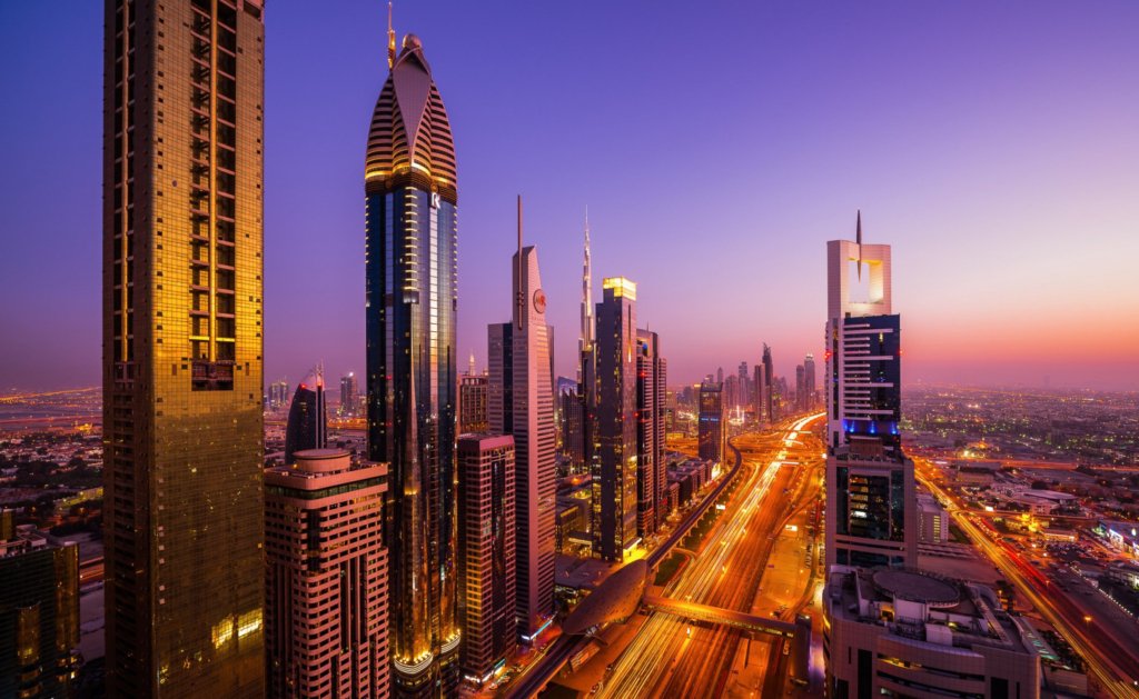 Dubai city skyline with illuminated buildings at sunset, showcasing off-plan real estate developments in DLRC