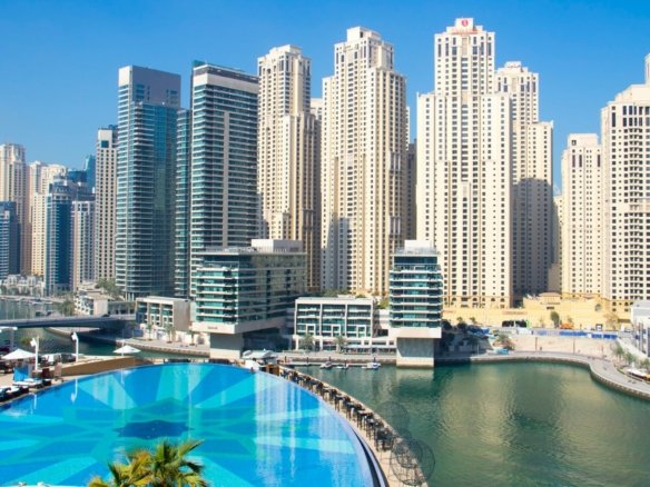 Hotel infinity pool overlooking Dubai Marina towers on a sunny day
