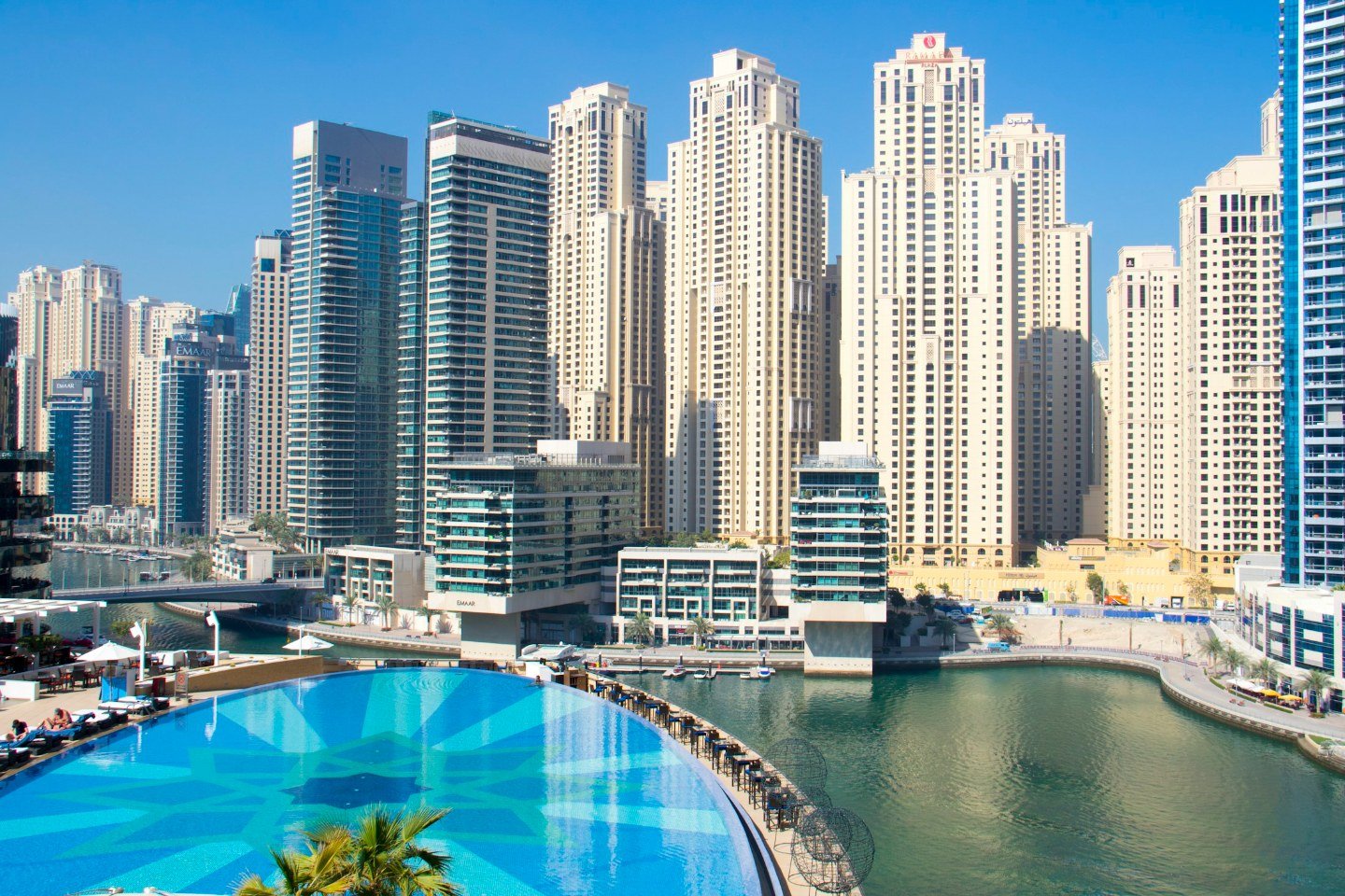 Hotel infinity pool overlooking Dubai Marina towers on a sunny day